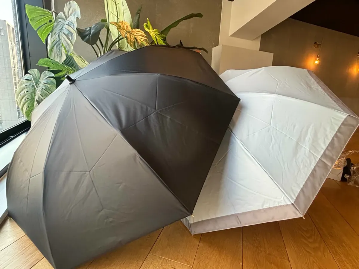 部屋に並べて立てた遮夏クール晴雨兼用傘2本(マットブラックとブルー)